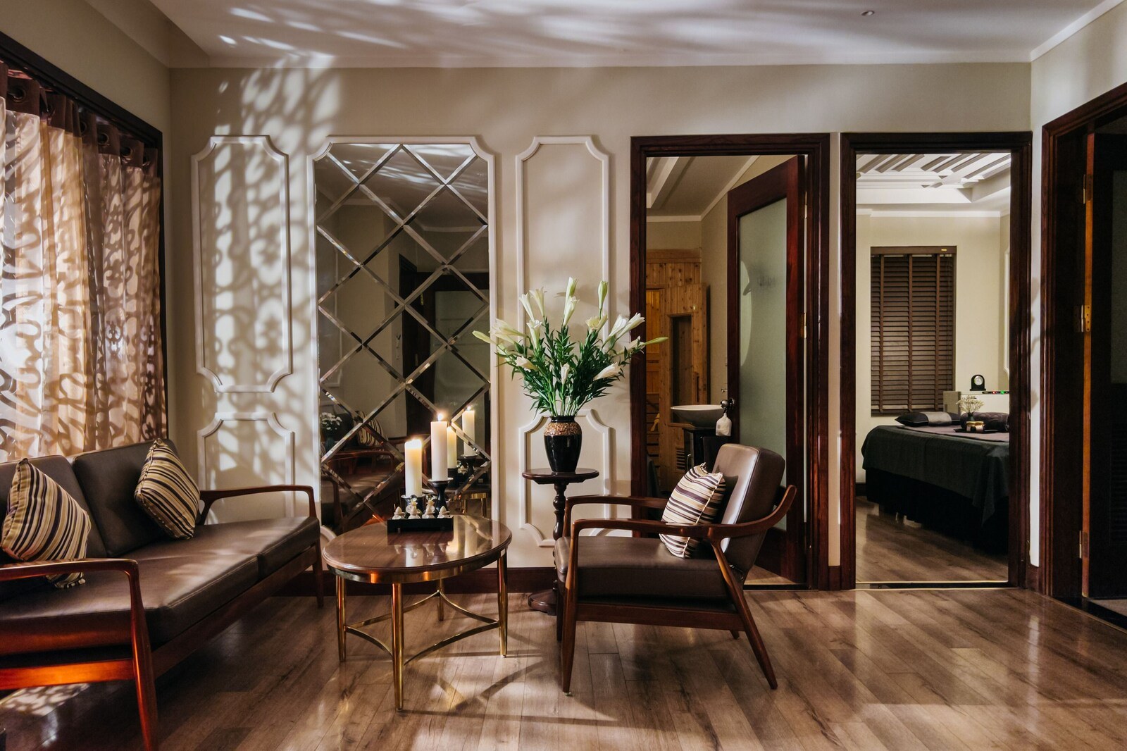 A room with a sofa, armchair, and a small table with candles and a plant. - La Siesta Classic Ma May (Hanoi)