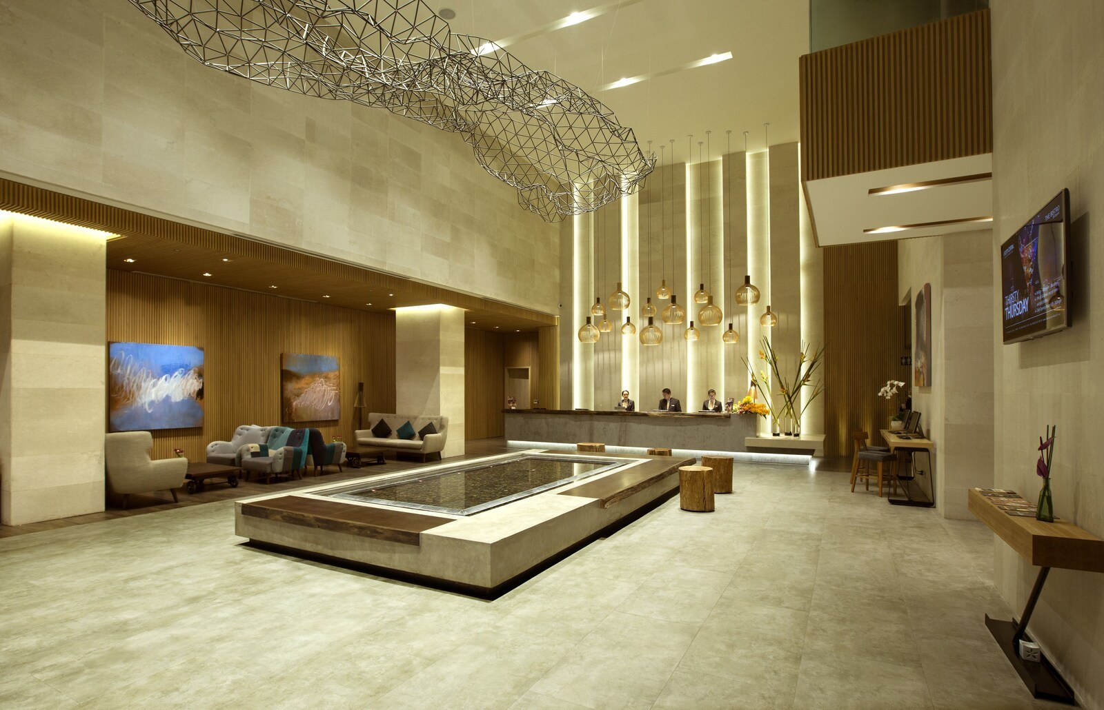 A modern lobby with a central heated pool, seating areas, and a reception desk. - Liberty Central Saigon Citypoint (Ho Chi Minh City)