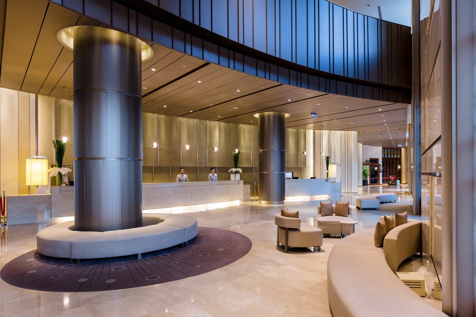 A modern lobby with a reception desk, seating areas, and a large central column. - Hotel Nikko Saigon (Ho Chi Minh City)